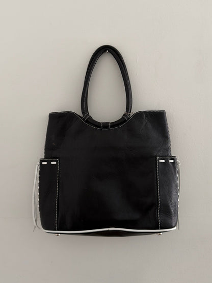 Black handbag with white accents on a light gray background