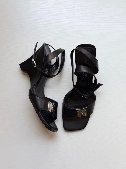 Pair of black high-heeled sandals on a white background