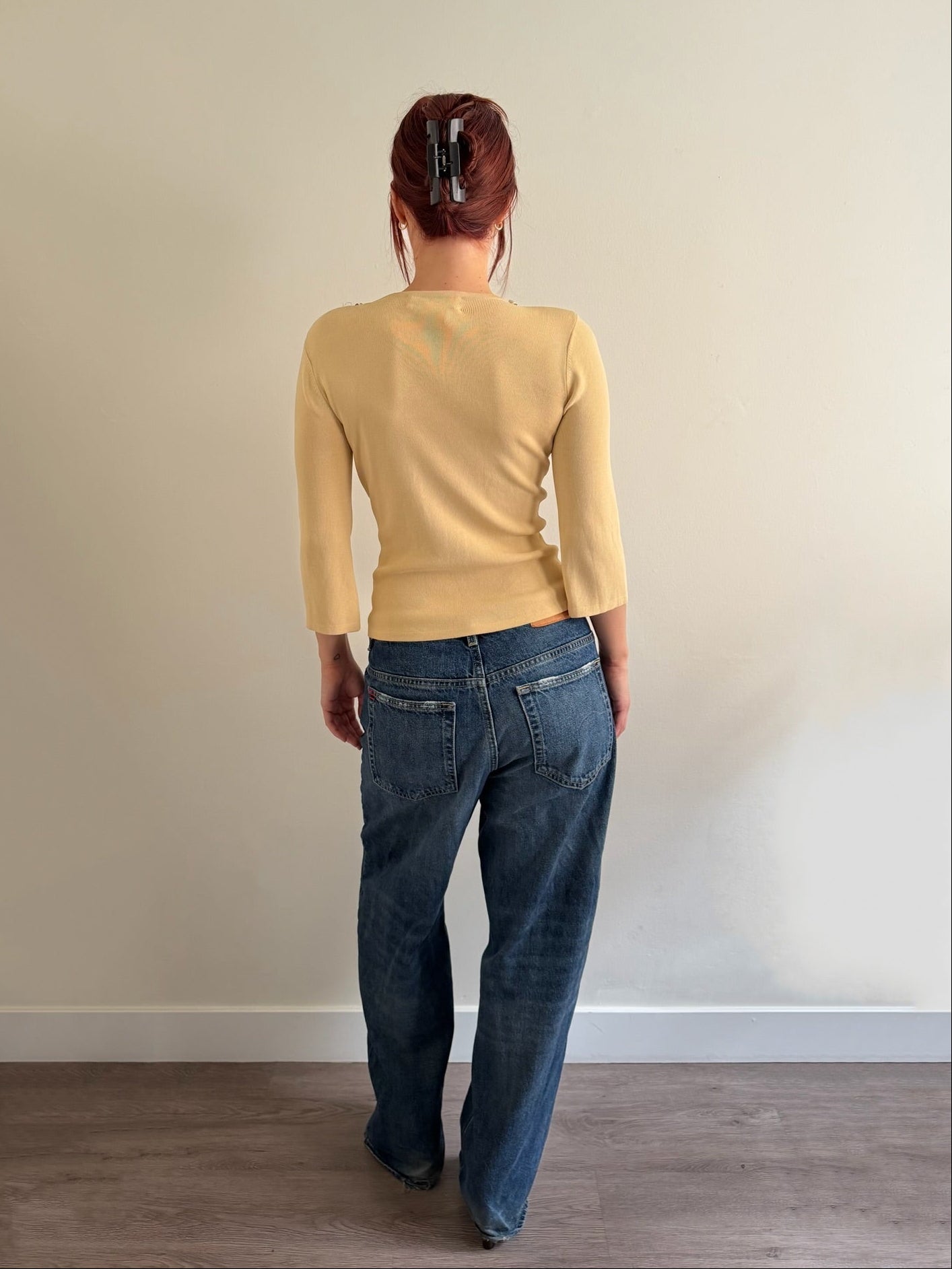 back of cream top and denim pants