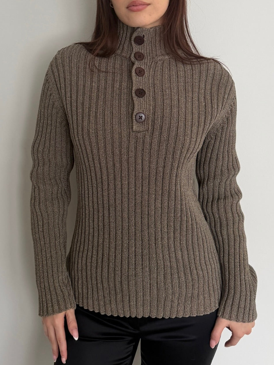 Brown ribbed sweater with button details worn by a person against a plain background