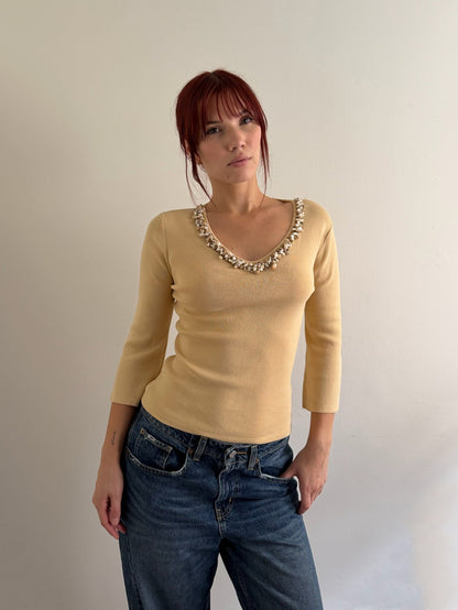 model with tan top and shell detail on the collar