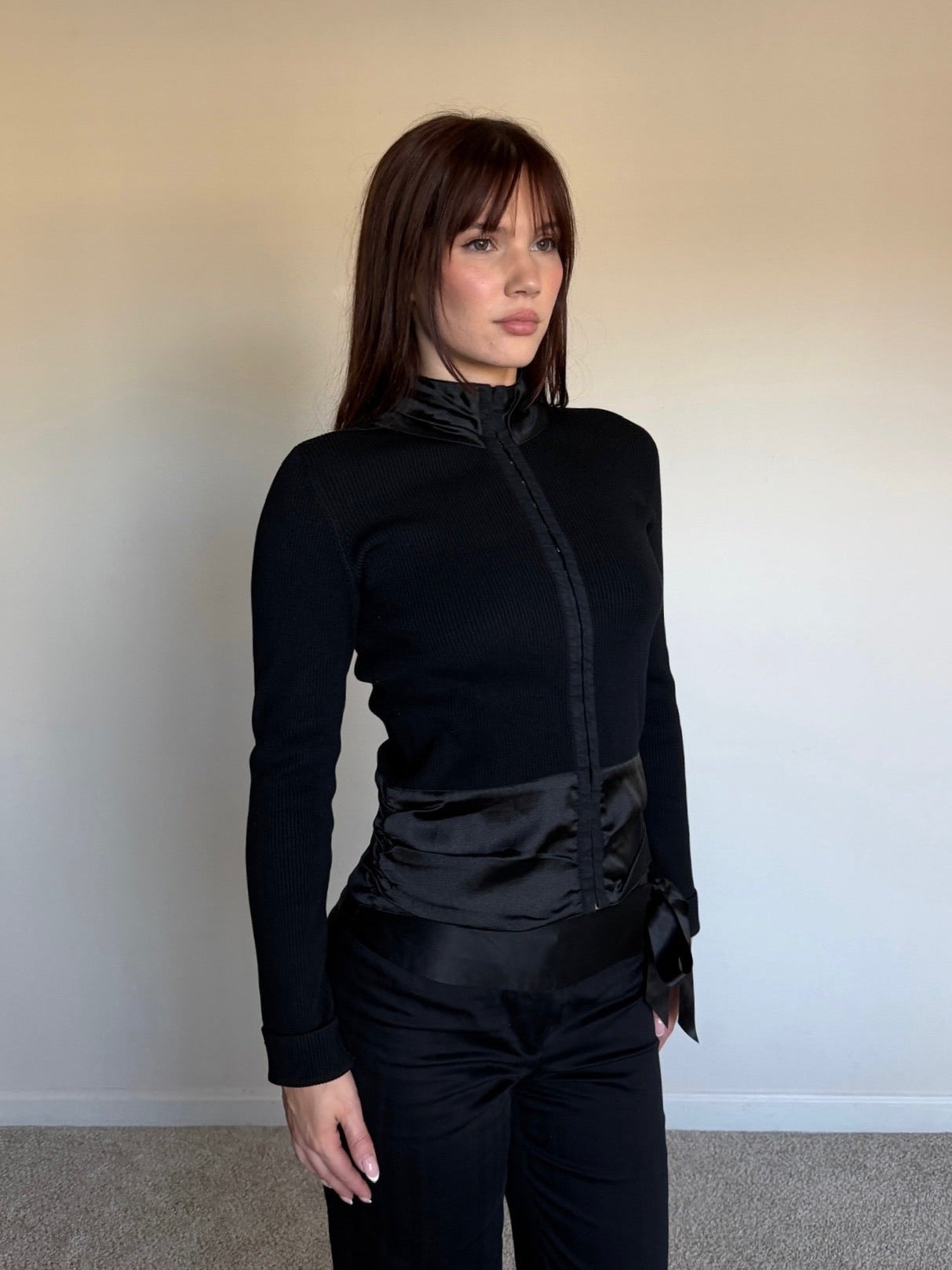 Woman wearing a black outfit against a plain background