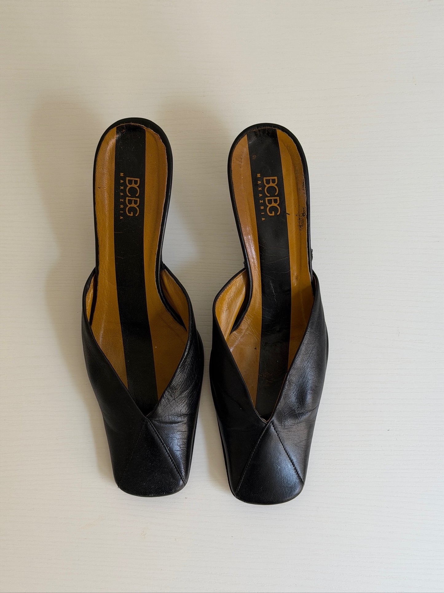 Pair of black high-heeled shoes with 'Boga' branding on a white background