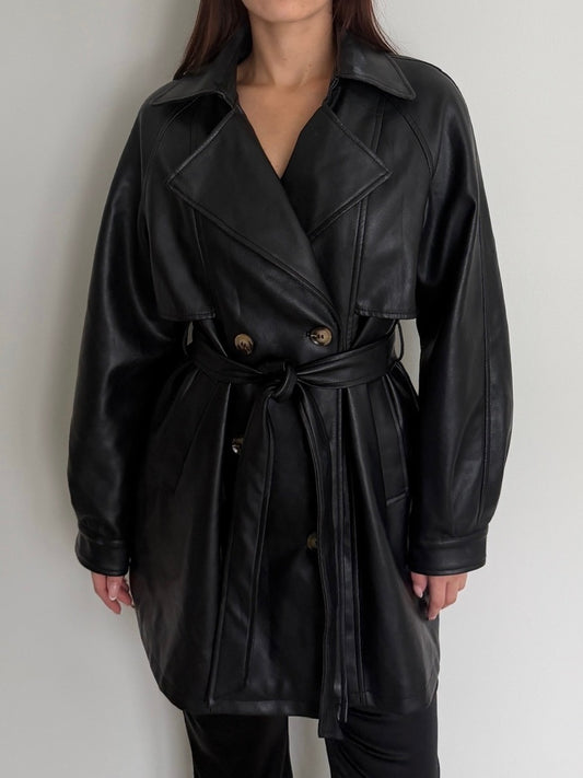 Black leather trench coat worn by a person on a plain background