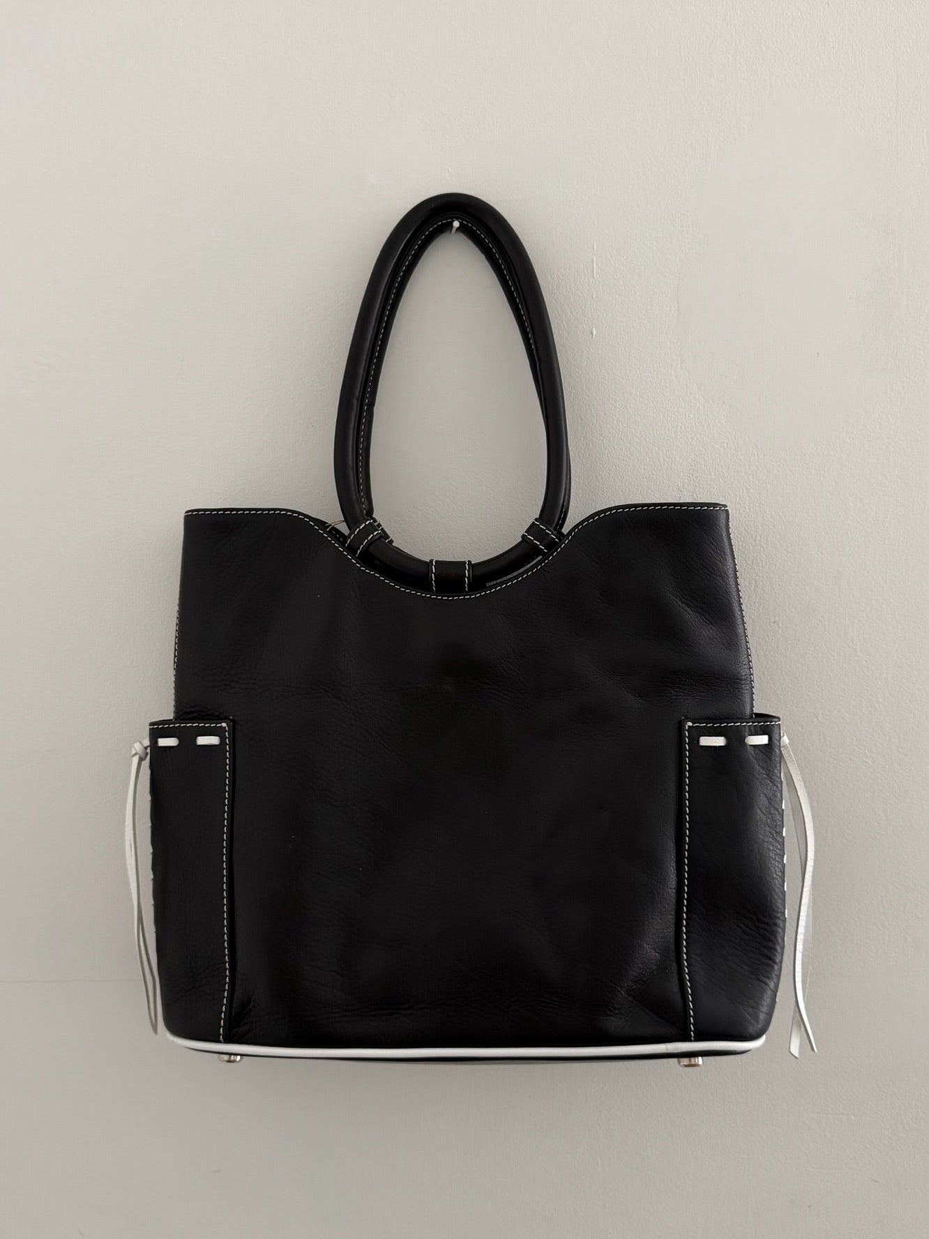 Black handbag with clear accents on a light gray background