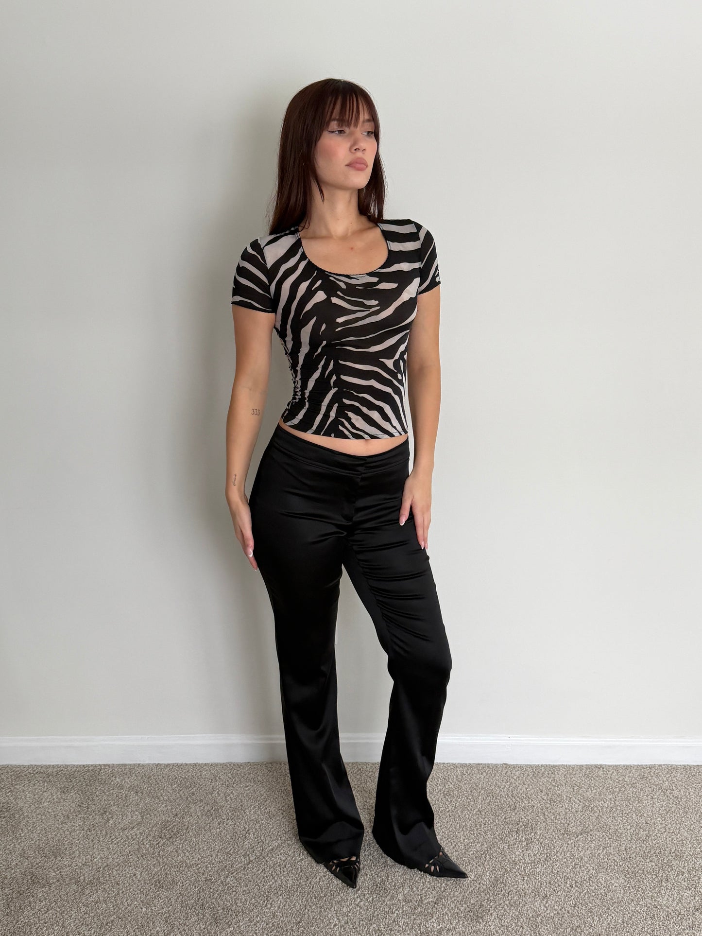 Person wearing a zebra print top and black pants 