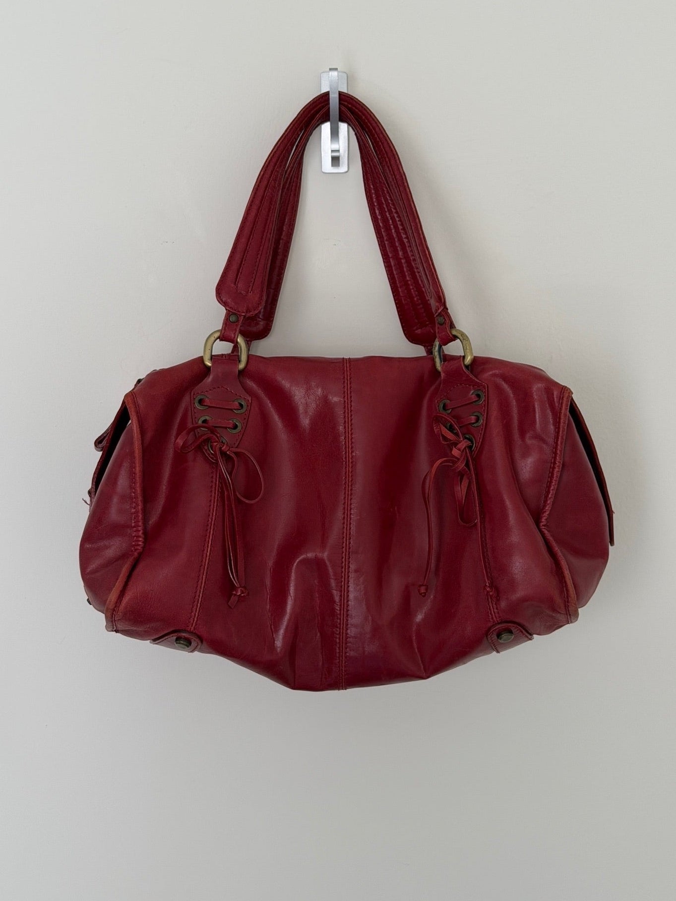 Red handbag hanging on a white wall