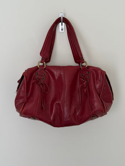 Red handbag hanging on a white wall