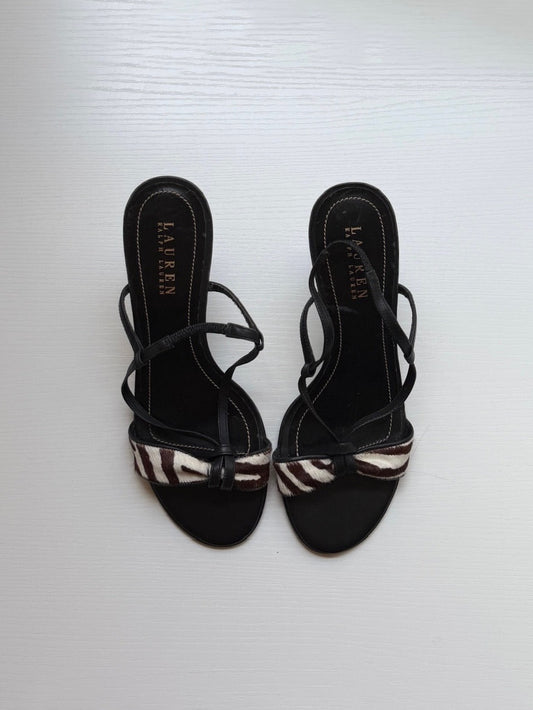 Black sandals with striped straps on a white background