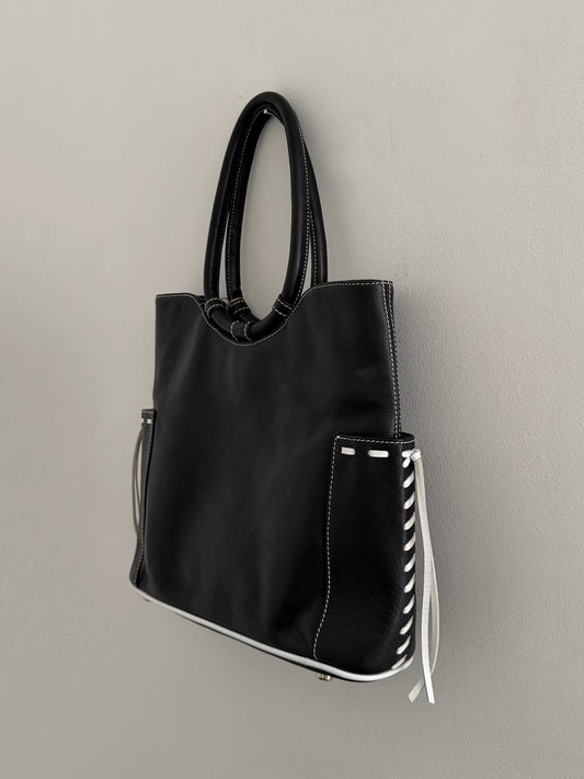 Black handbag with white accents on a gray background