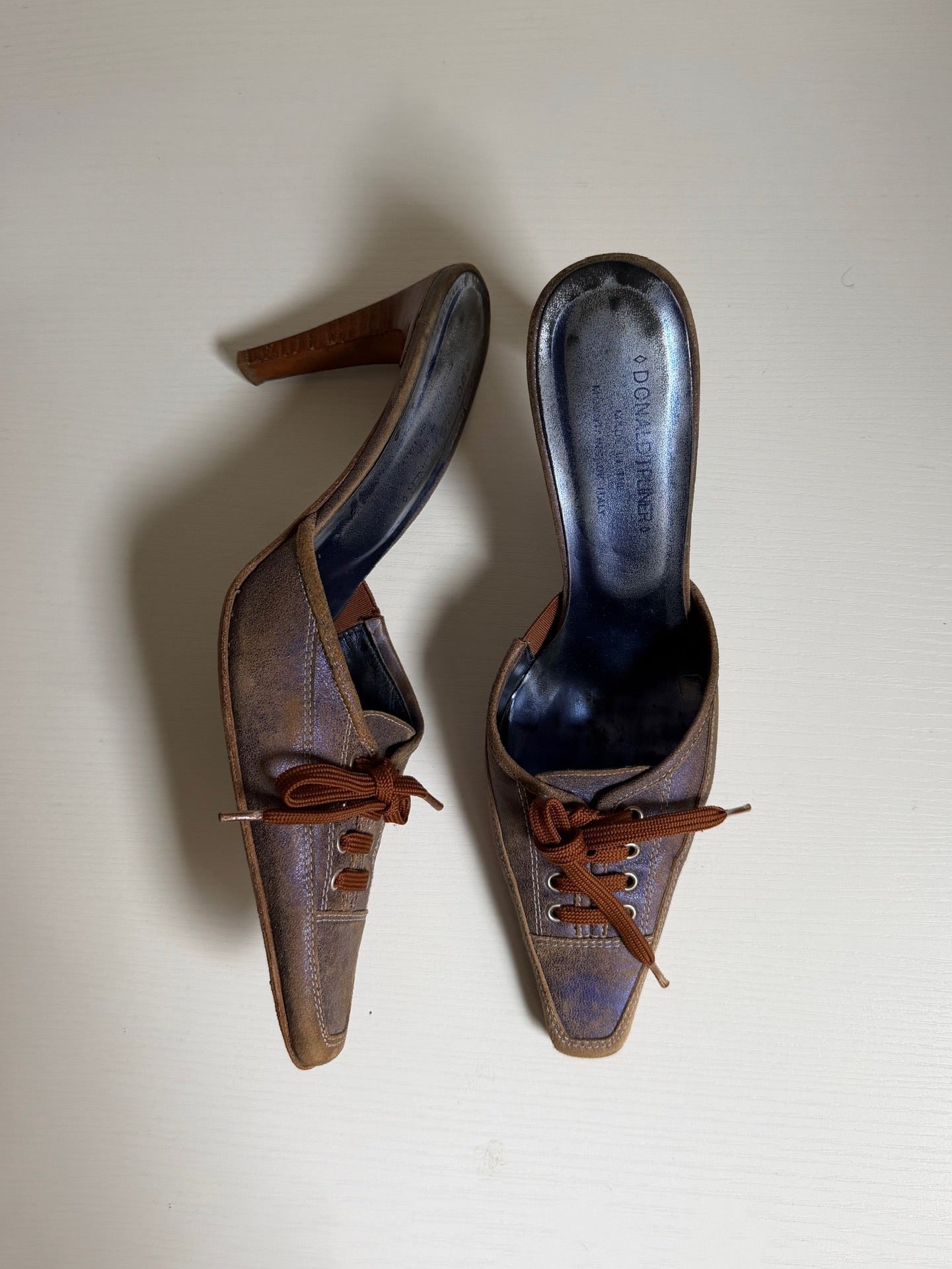 Pair of vintage brown high-heeled shoes on a white background