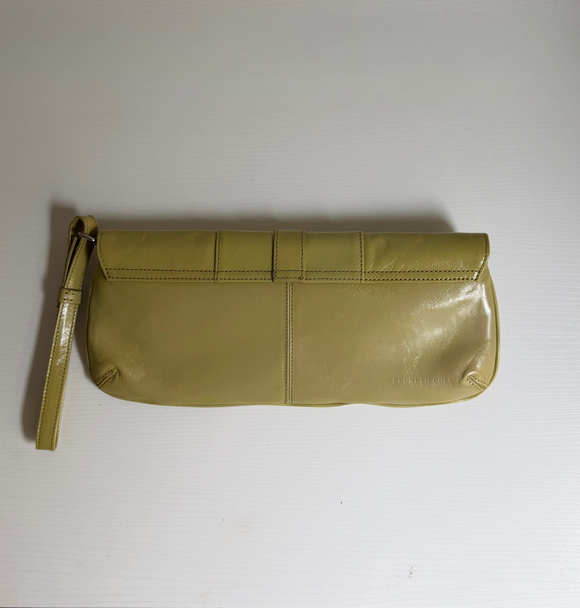 Green clutch bag on a white surface