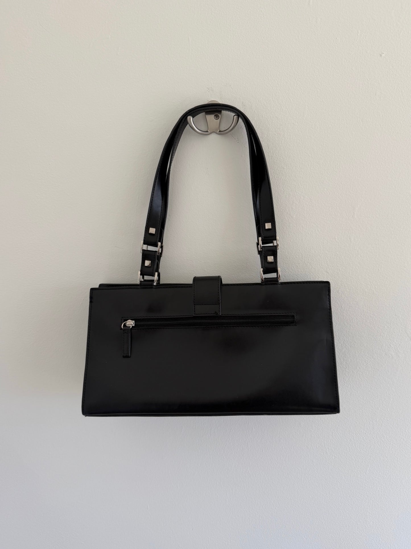 Black handbag with a strap on a white background