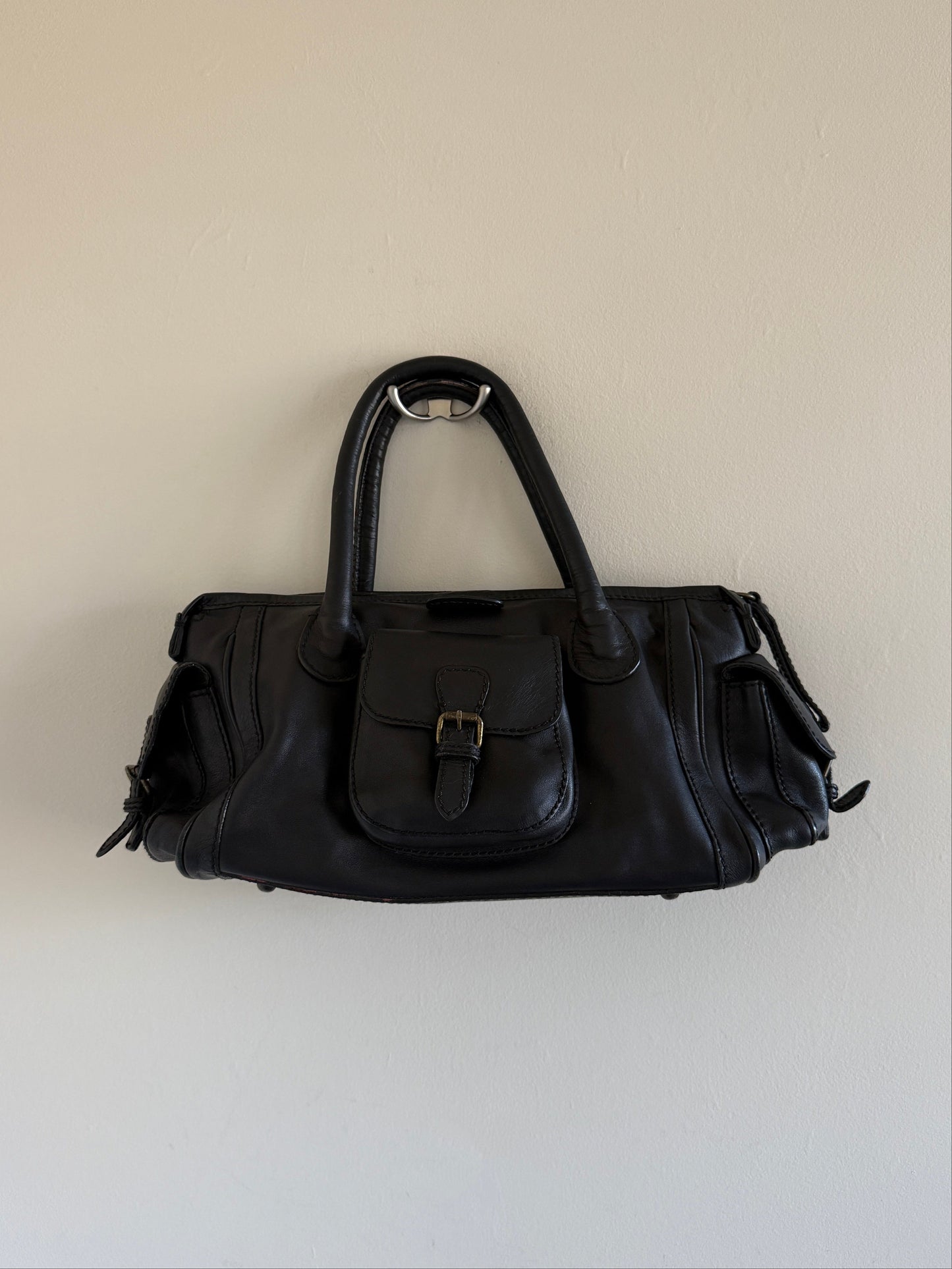 Black handbag on a light beige background