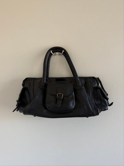 Black handbag on a light beige background