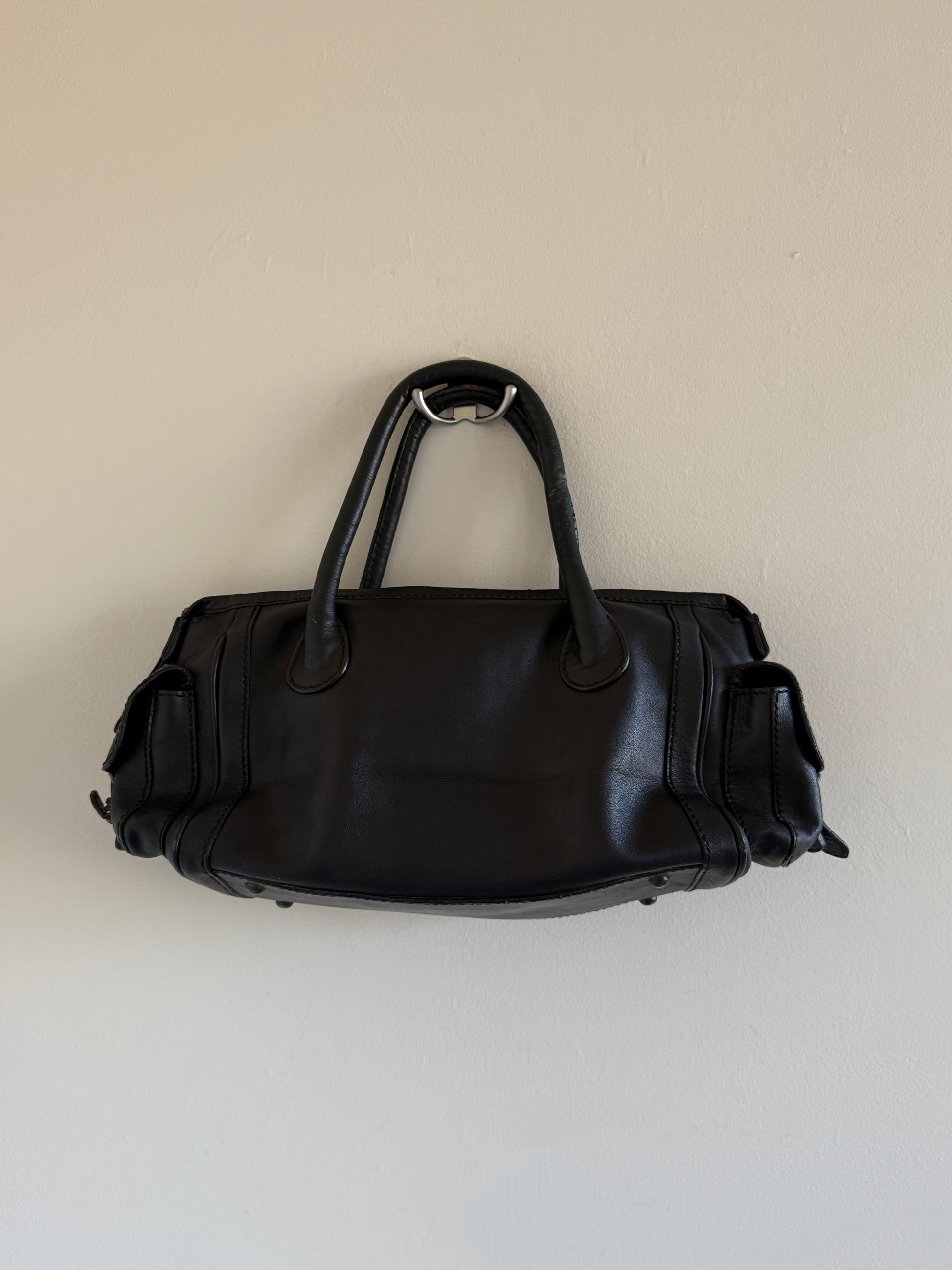 Black leather bag on a beige background