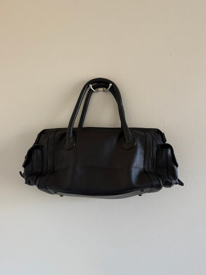 Black leather bag on a beige background