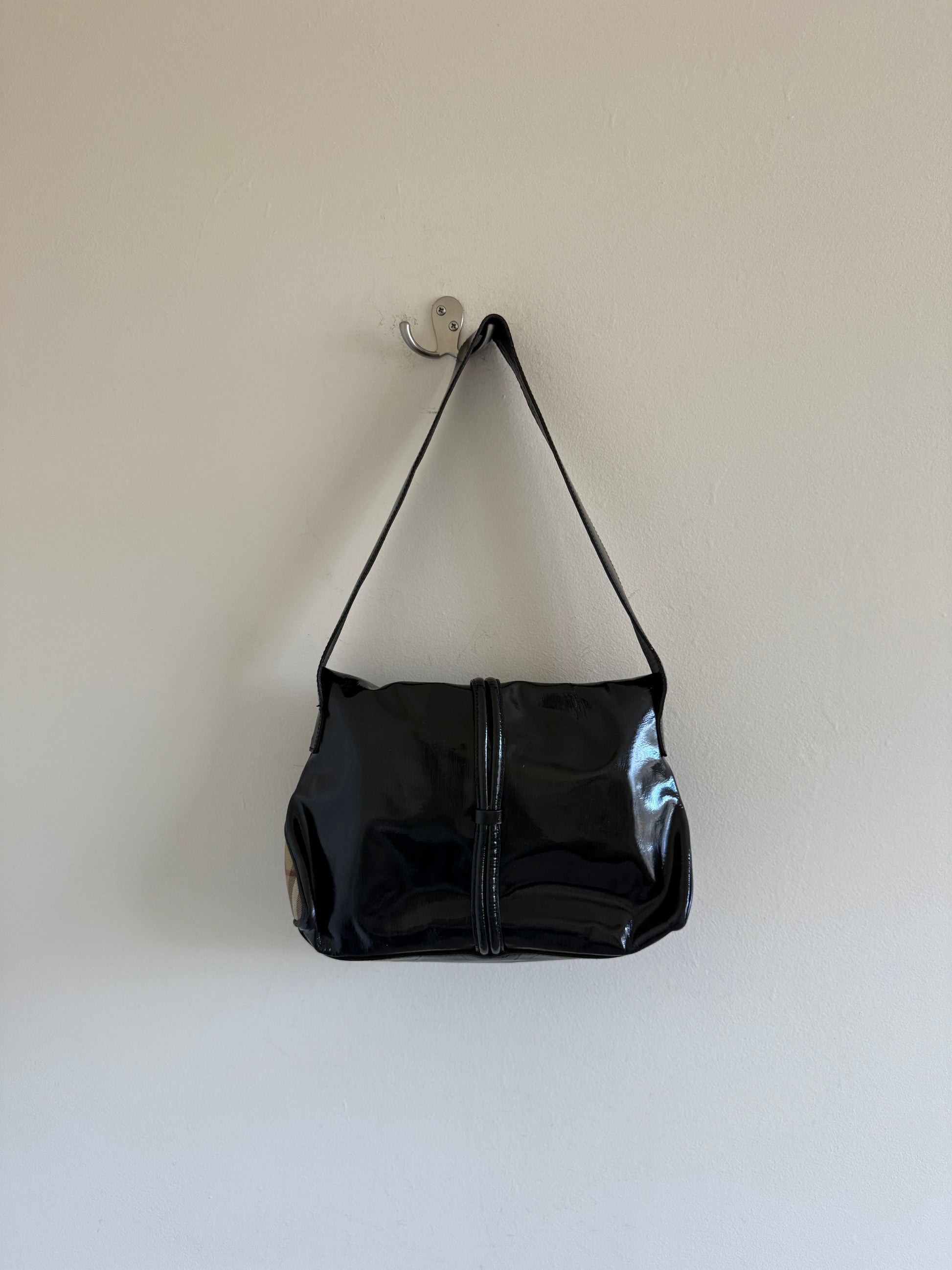 Black handbag hanging on a white wall
