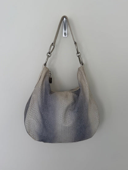 Gray textured handbag with a strap on a light gray background