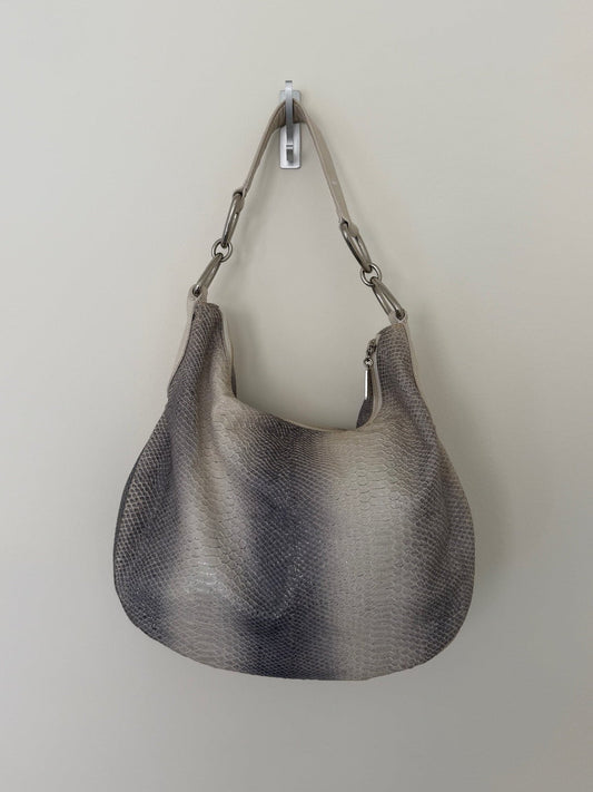 Gray textured handbag hanging on a white wall