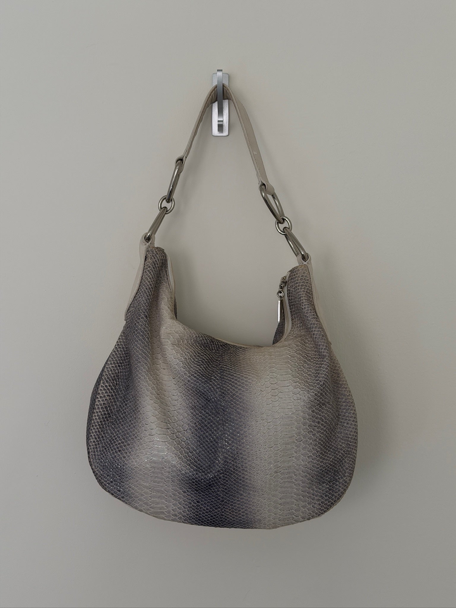 Gray handbag with chain handle on a light gray background