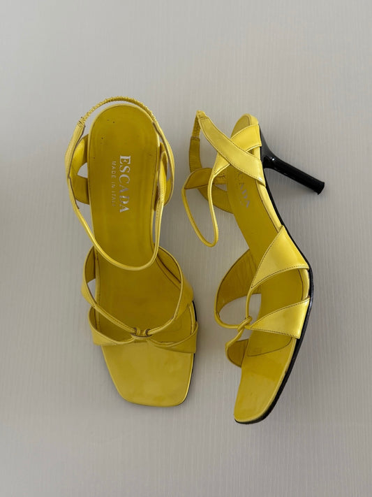 Yellow high-heeled sandals with 'ESPA' branding on a light gray background