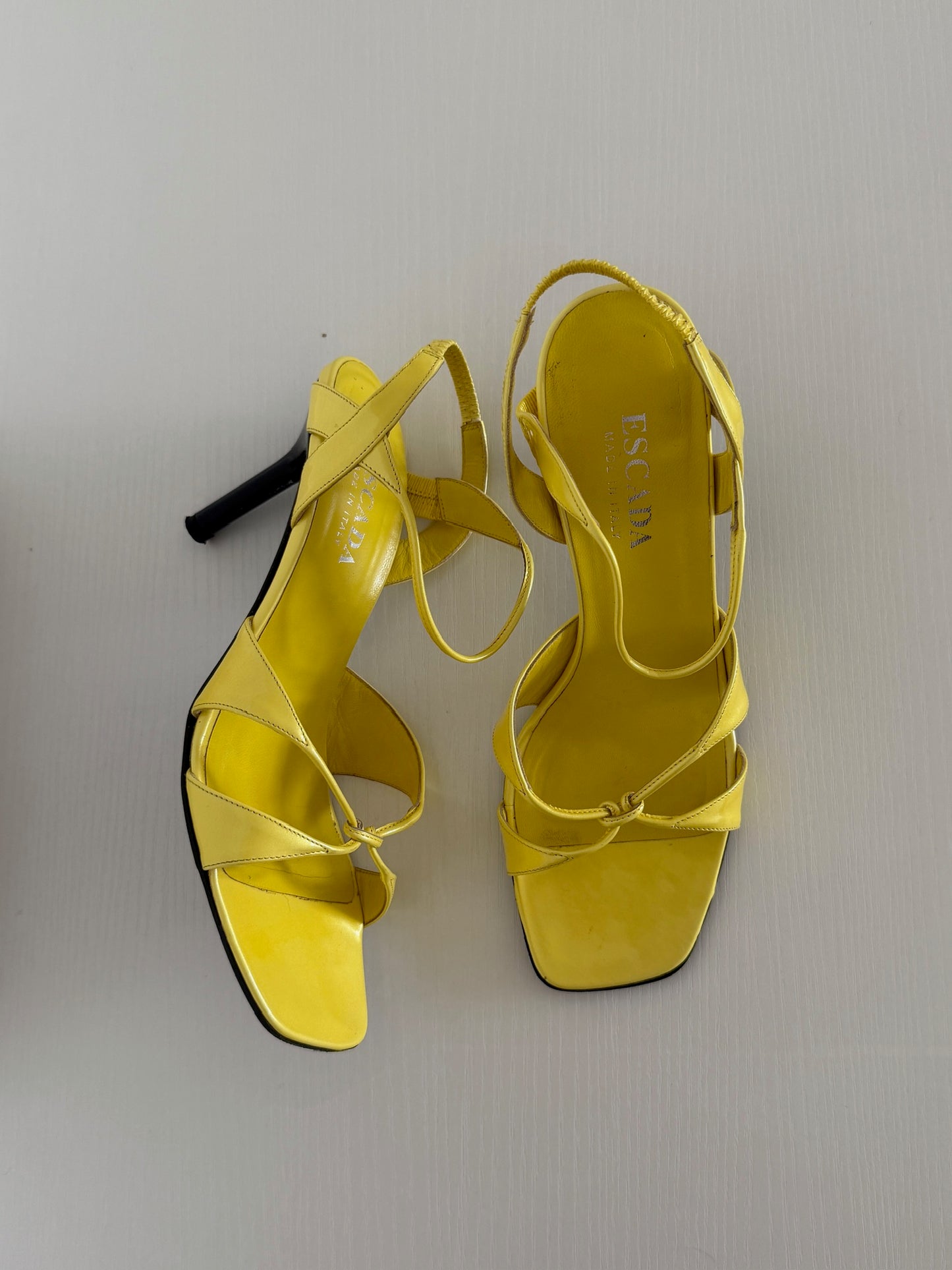 Yellow high-heeled sandals on a light gray background