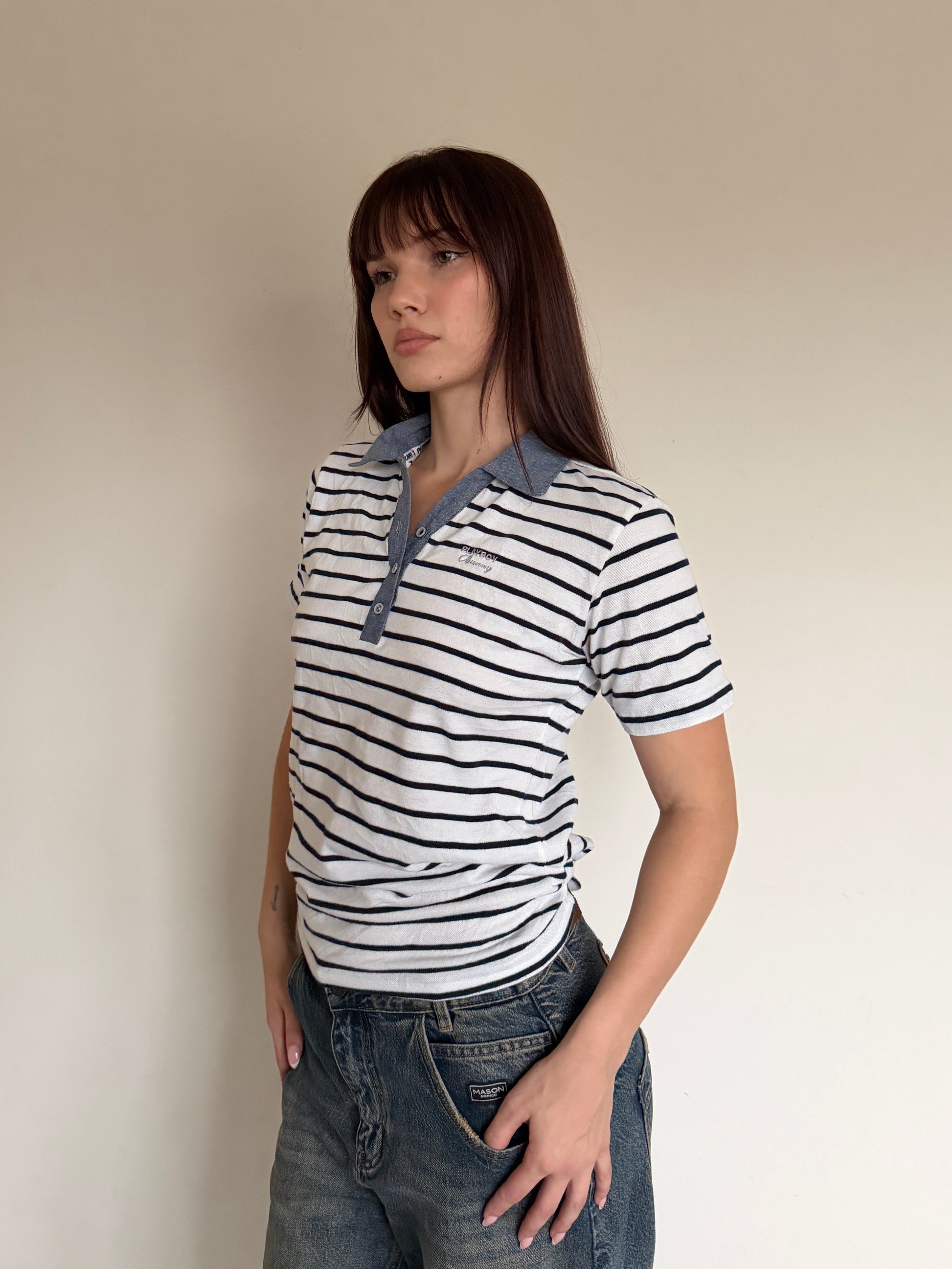Woman wearing a striped shirt with a collar against a plain background