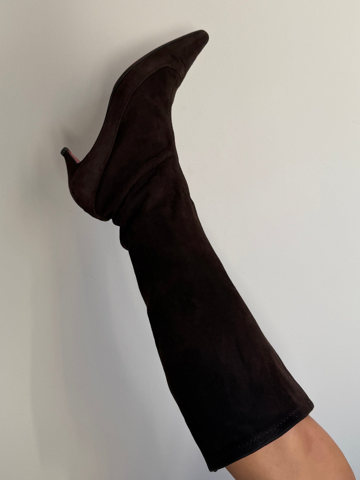 Black knee-high boot on a plain background