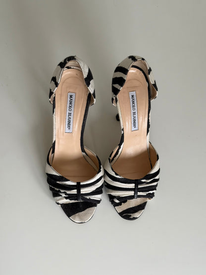 Pair of black and white striped high-heeled shoes on a light gray background