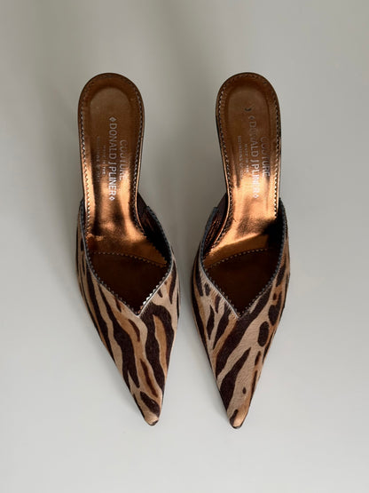 Pair of leopard print pointed-toe mules on a light gray background