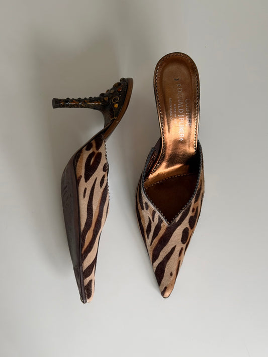 Pair of leopard print high-heeled shoes on a light gray background