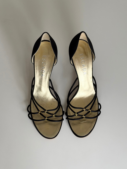 Black strappy high-heeled shoes on a light gray background