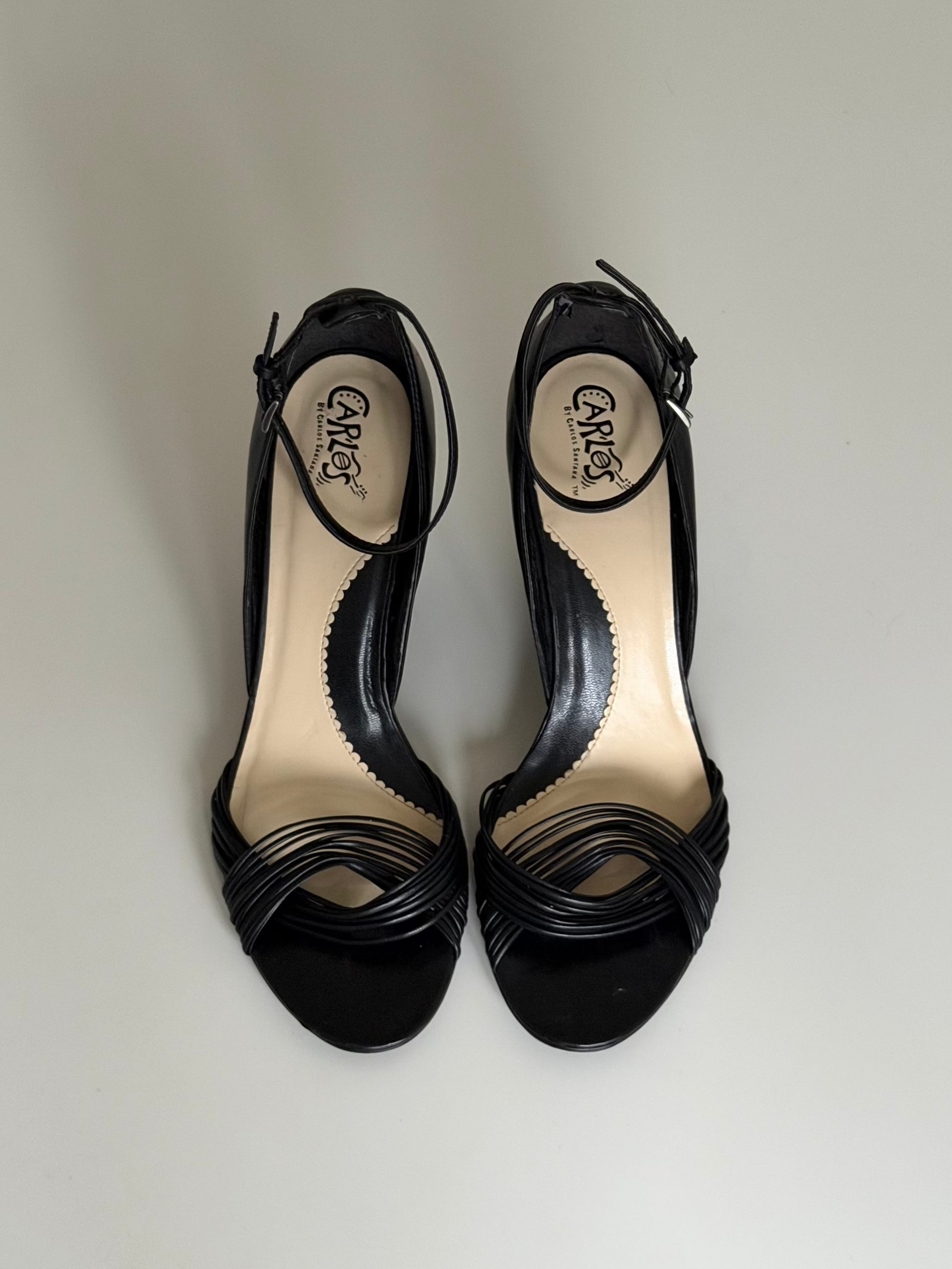 Pair of black high-heeled shoes on a light gray background