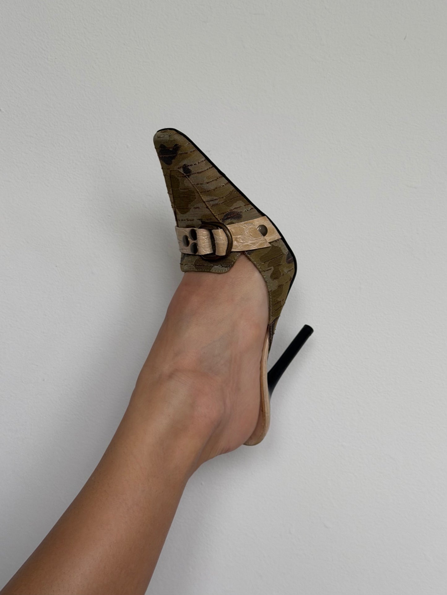 High-heeled shoe with a strap on a light gray background
