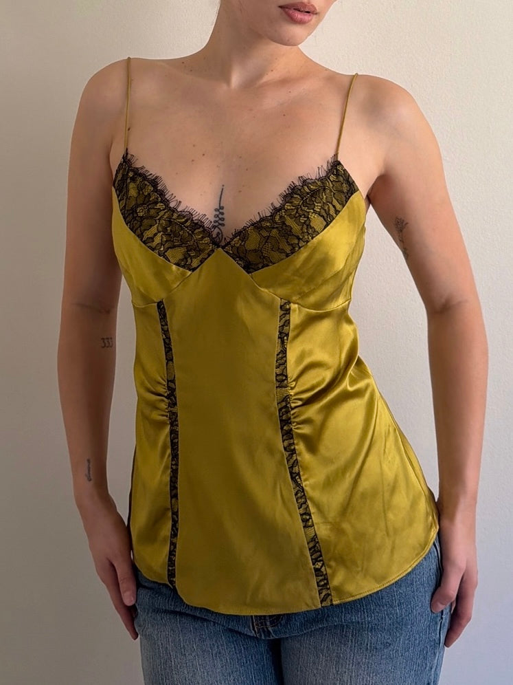 Yellow satin camisole with lace trim worn by a person against a neutral background