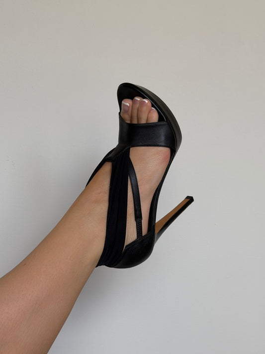 Black high-heeled sandal on a neutral background