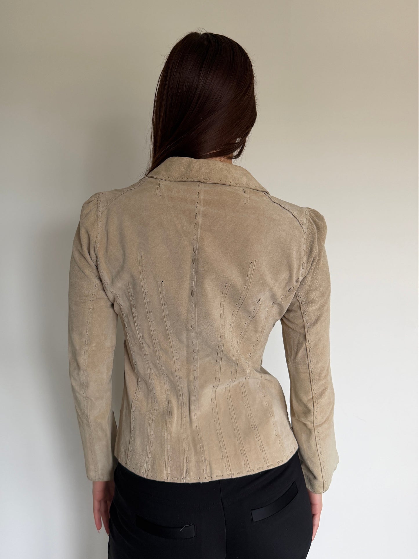 Person wearing a beige corduroy jacket against a plain background