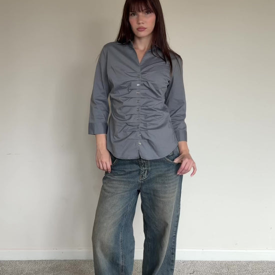 Person wearing a gray button-up shirt 