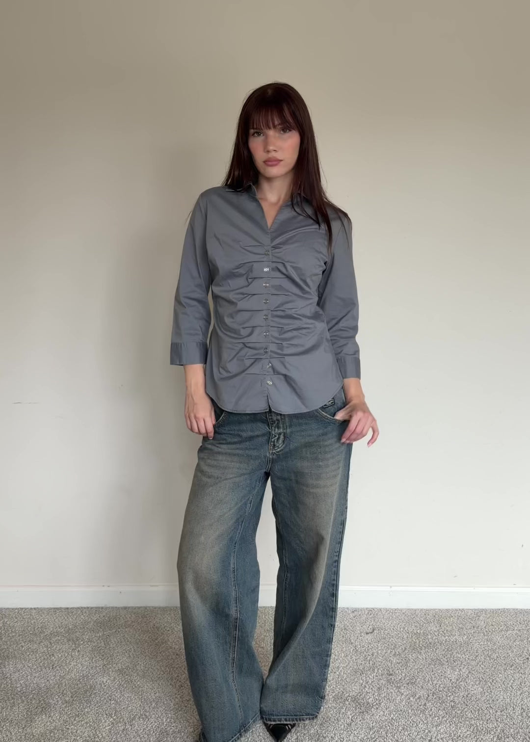 Person wearing a gray button-up shirt 