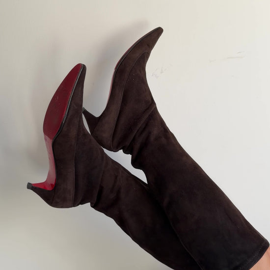 Brown knee-high boots worn by a person on a plain background