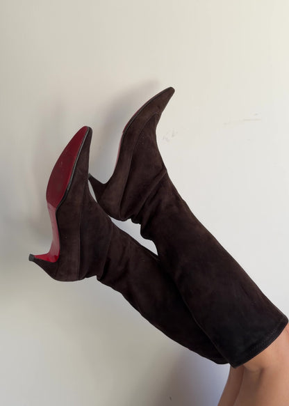 Brown knee-high boots worn by a person on a plain background